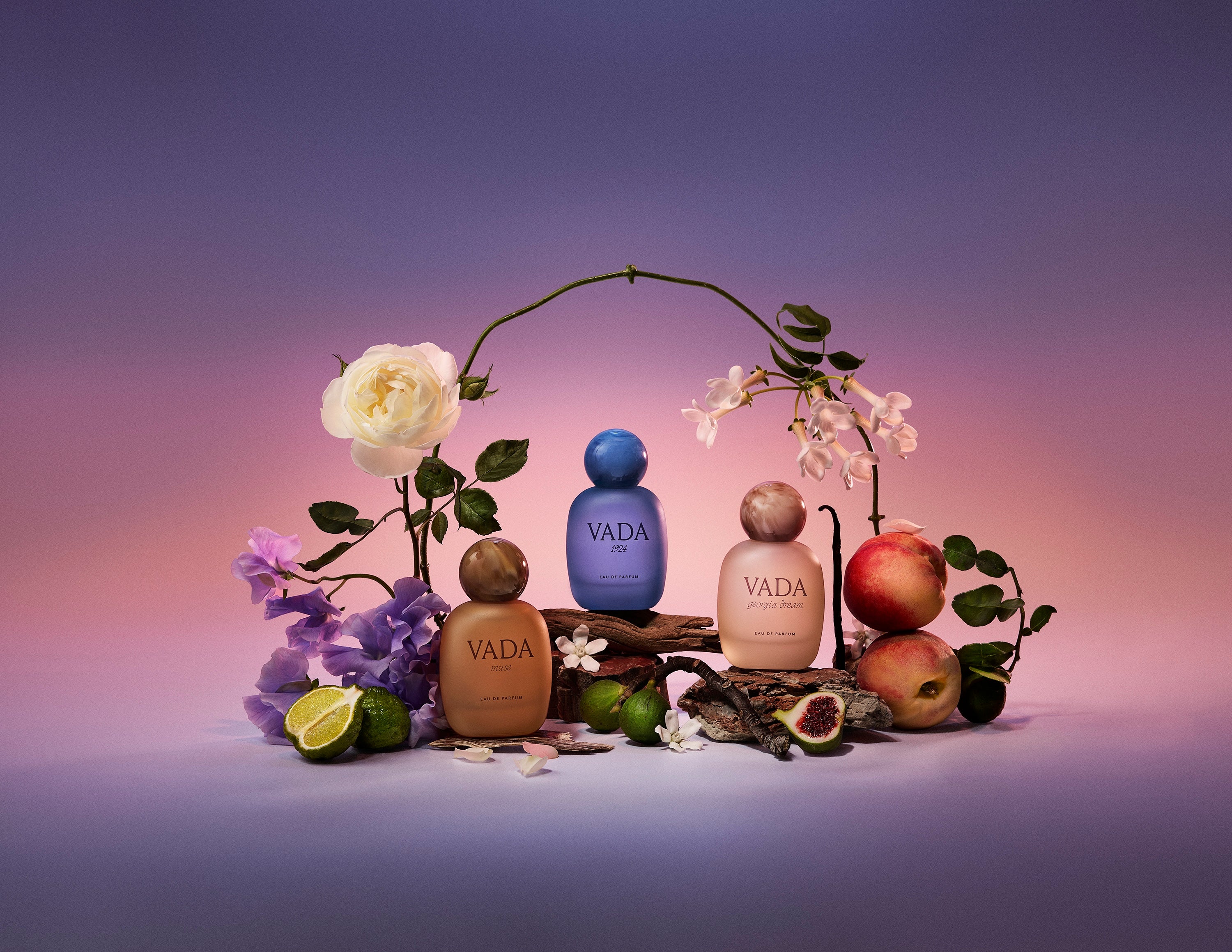 Vada perfume bottles with flowers and fruits on a gradient background