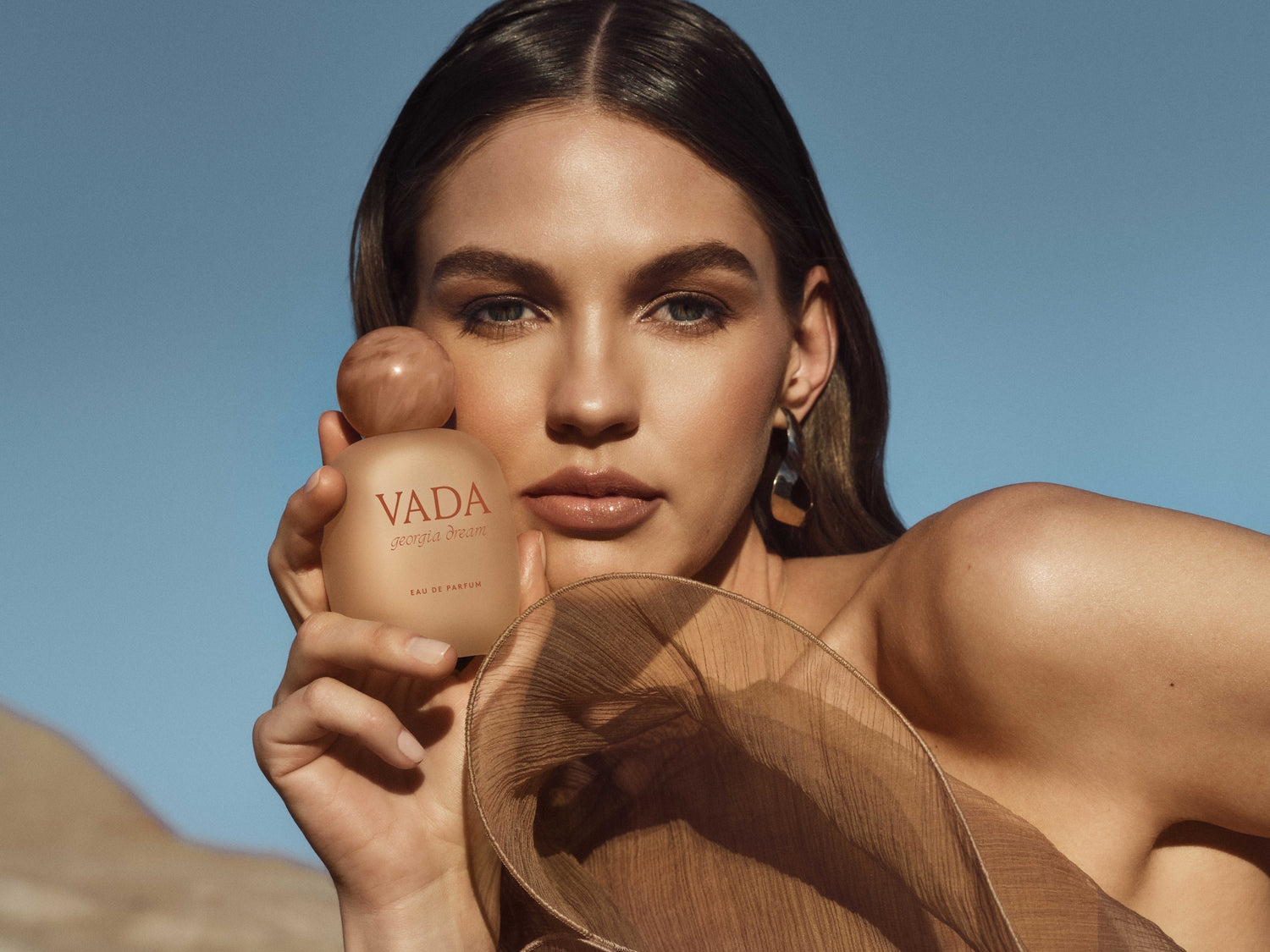 Woman holding a Vada product against a clear blue sky