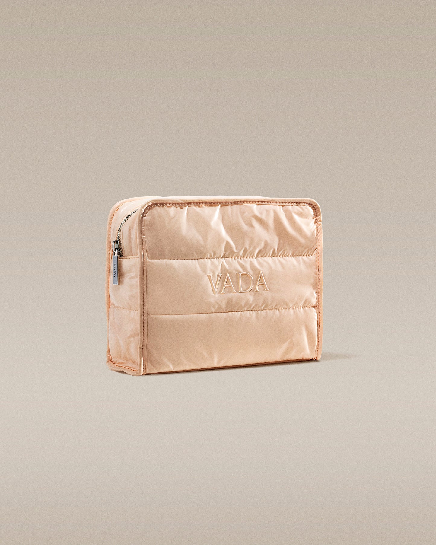 Beige quilted pouch with 'Vada' branding on a beige background