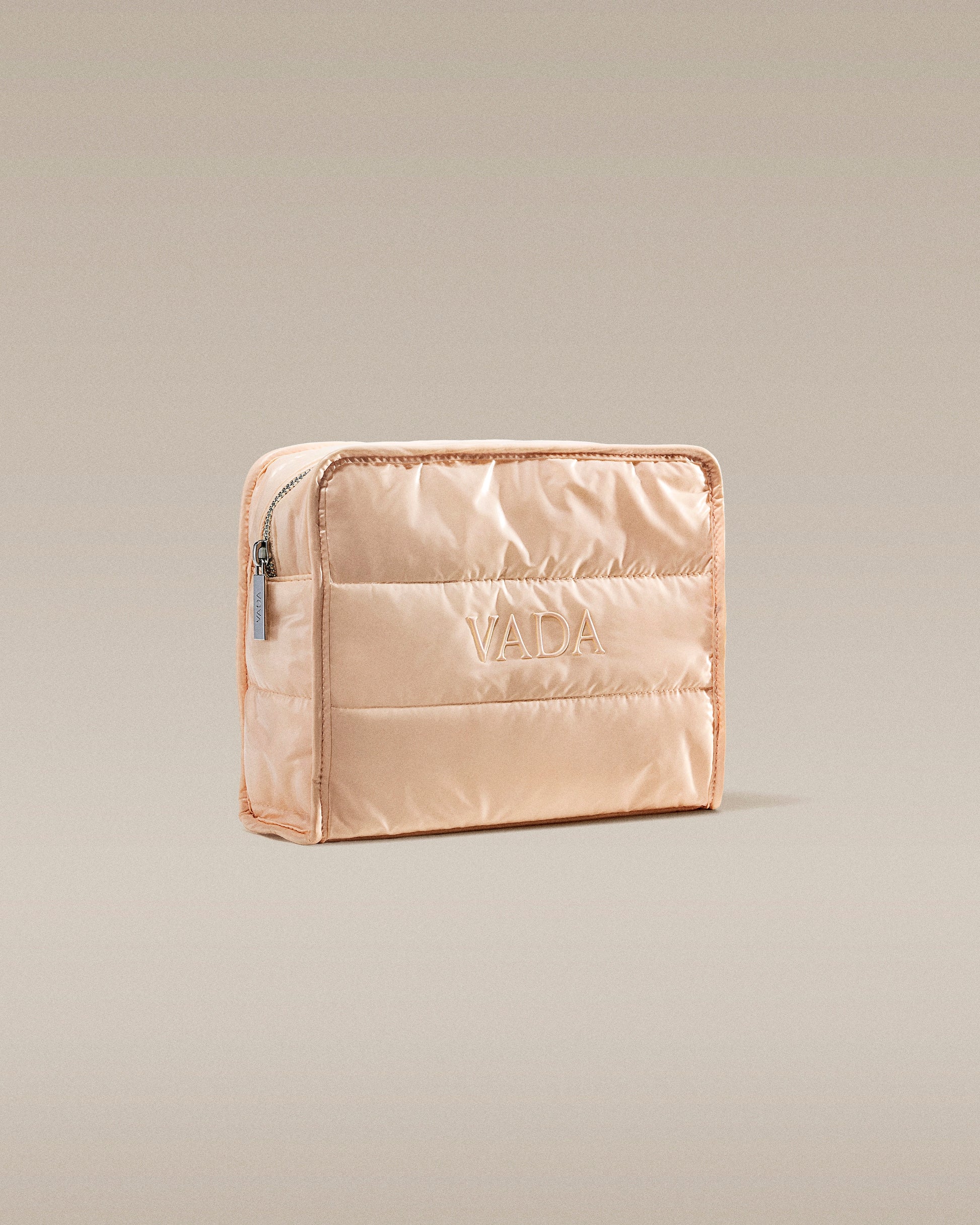 Beige quilted pouch with 'Vada' branding on a beige background